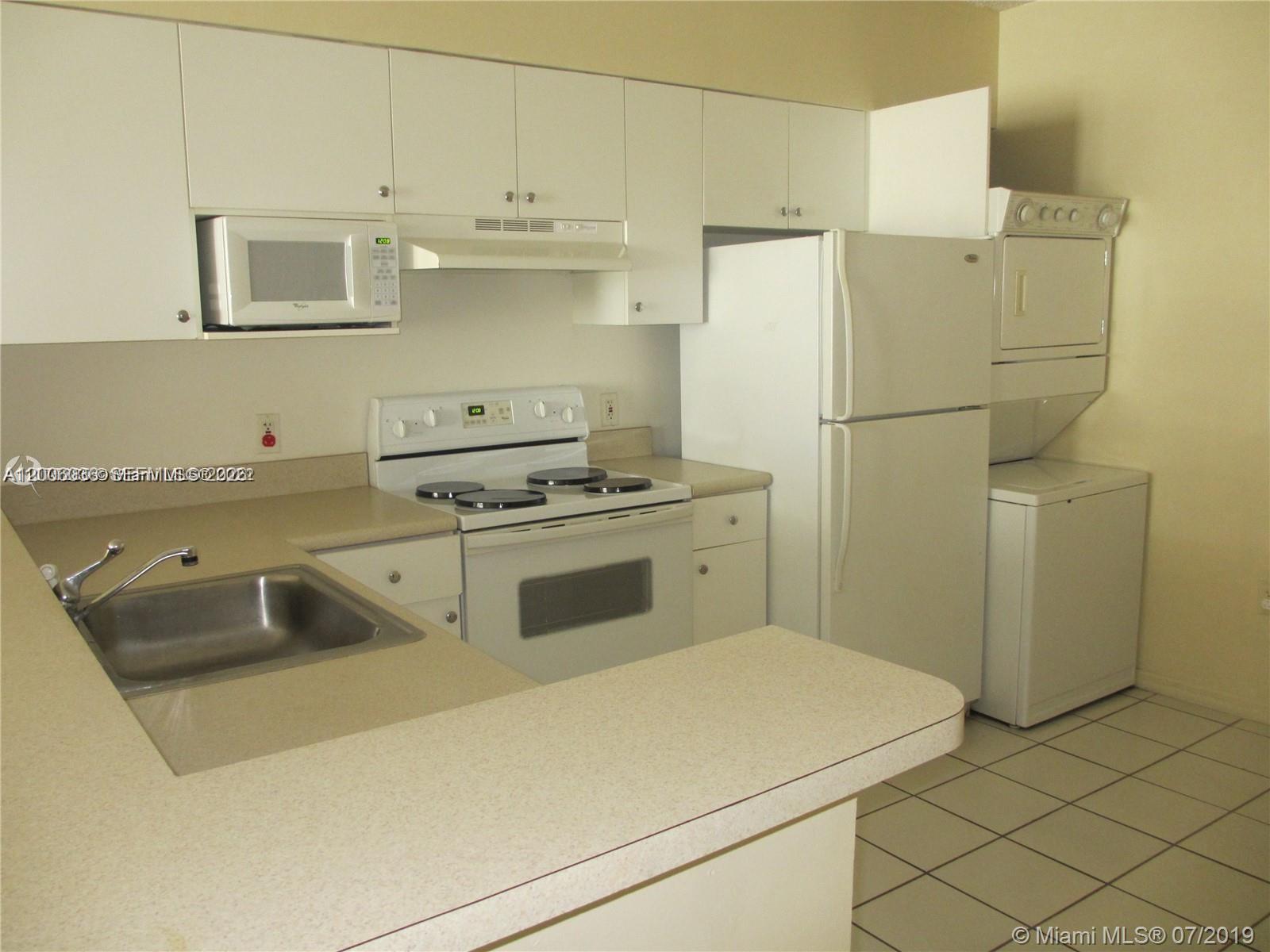 A kitchen features white cabinets, white appliances, a stainless steel sink, and tiled flooring — 5091 NW 7th St # 807, Miami FL 33126, MIAMI, FL