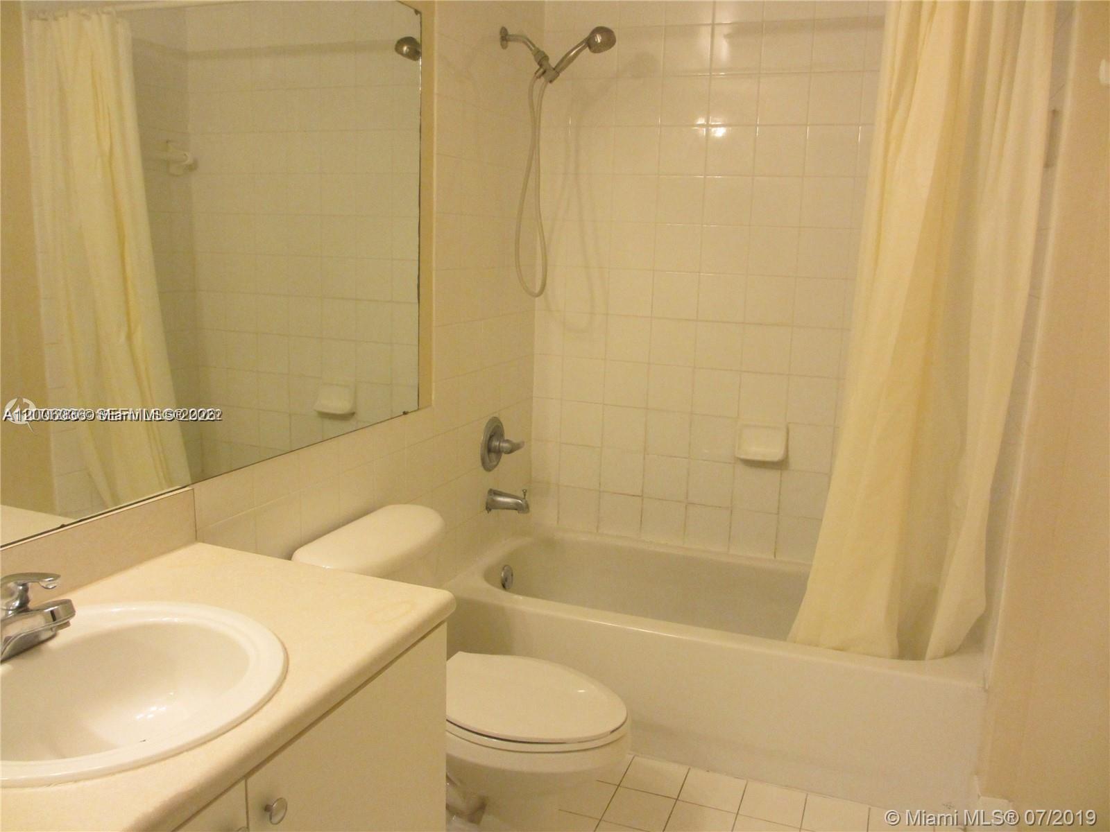 A bathroom features a white vanity, a toilet, and a shower-tub combination with tiled walls — 5091 NW 7th St # 807, Miami FL 33126, MIAMI, FL