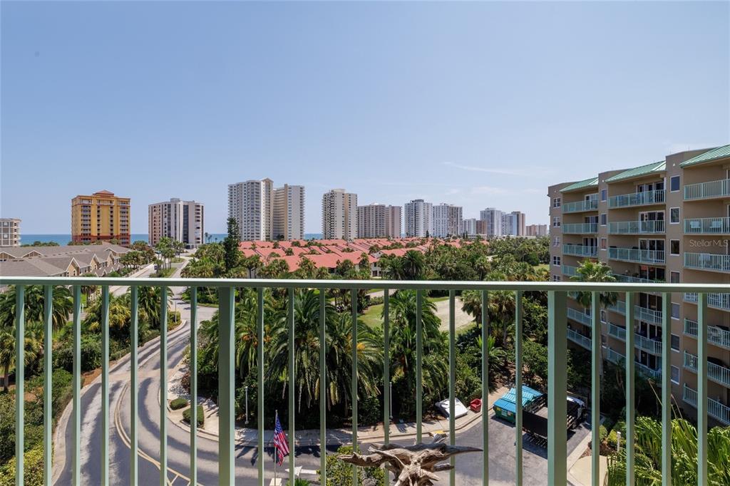 A balcony view overlooking a coastal landscape with high-rise buildings, palm trees, and a road — 4 OCEANS WEST BOULEVARD UNIT 601A, DAYTONA BEACH SHORES, FL
