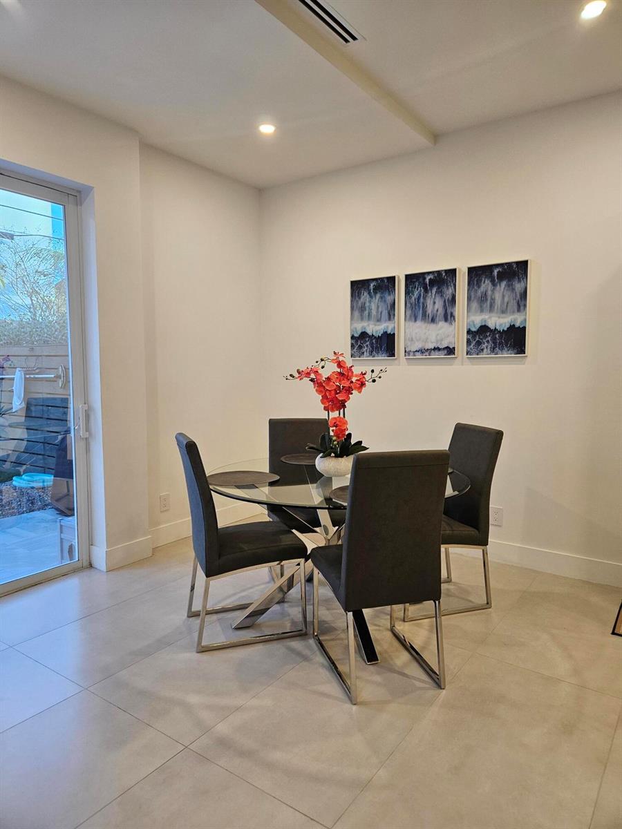 A dining area features a glass table, four gray chairs, and three abstract wall art pieces — 2275 SE 7th Street, Pompano Beach FL 33062, POMPANO BEACH, FL