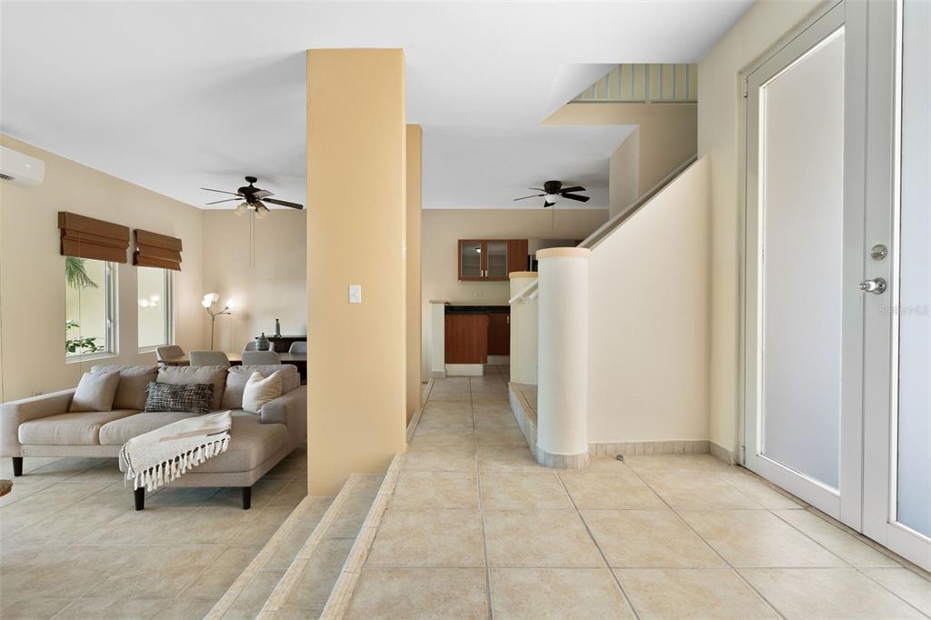 A living room with a sunken seating area, tile floors, and a staircase — 90 CANDELERO DRIVE UNIT 13, HUMACAO, PR