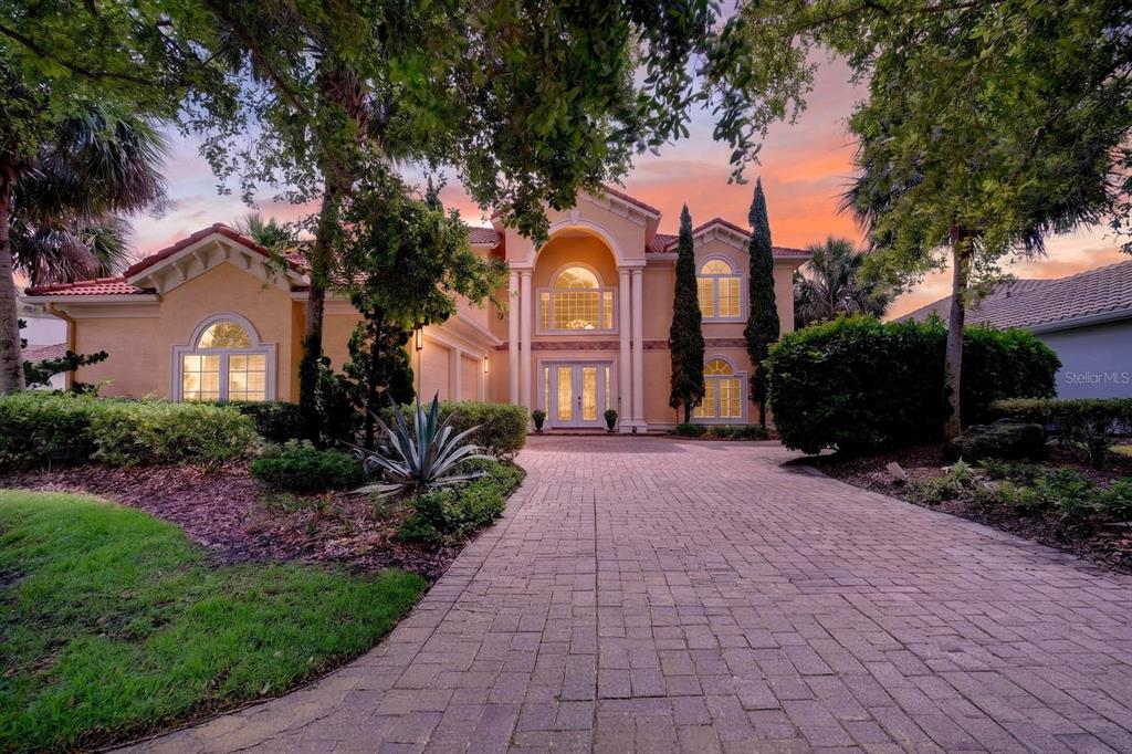 A two-story stucco house with a paved driveway and arched windows at sunset — 18 HAMMOCK BEACH PARKWAY, PALM COAST, FL