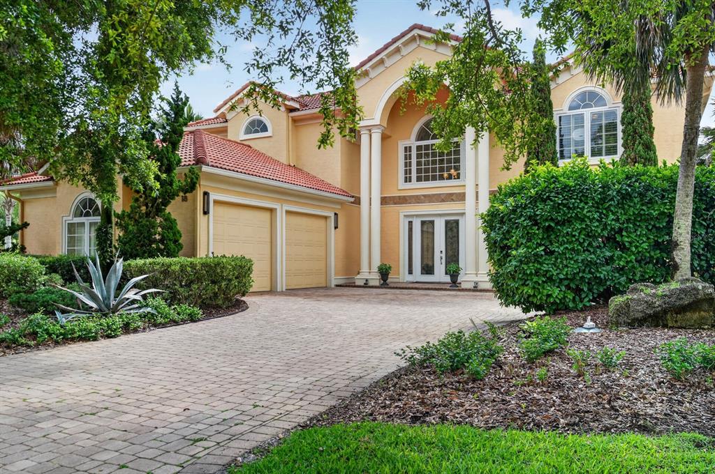 A two-story stucco house with a tile roof, arched windows, and a paved driveway — 18 HAMMOCK BEACH PARKWAY, PALM COAST, FL