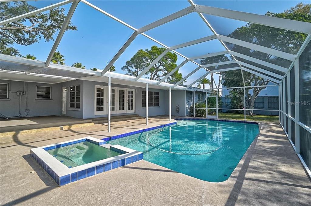 A screened-in patio features a rectangular swimming pool and an attached tiled hot tub — 1958 MORRIS STREET, SARASOTA, FL
