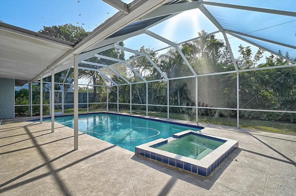 A swimming pool and attached hot tub are enclosed within a screened-in patio area — 1958 MORRIS STREET, SARASOTA, FL
