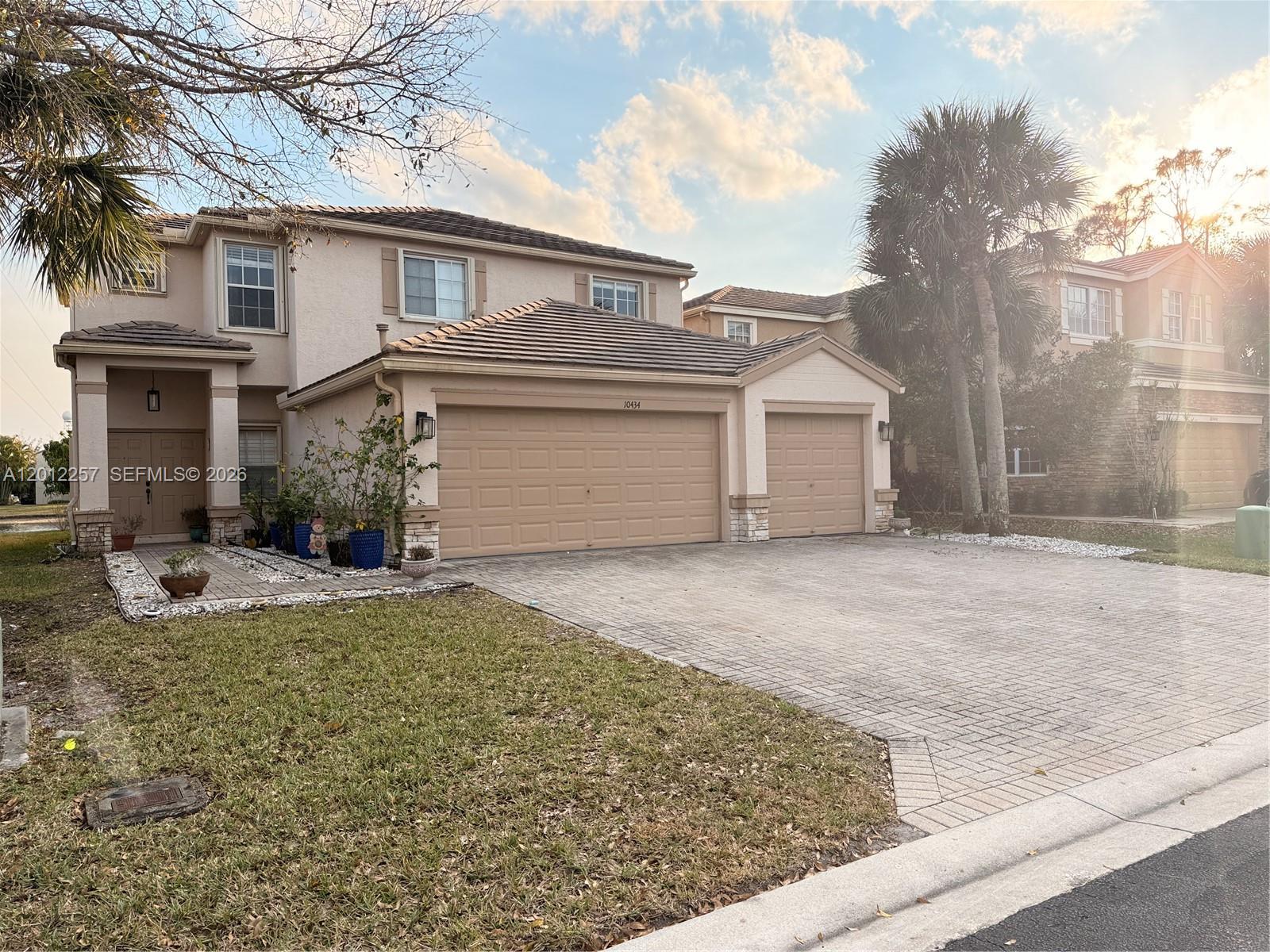 A two-story suburban house features a three-car garage and a paved driveway — 10434 White Pinto Ct, Lake Worth FL 33449, LAKE WORTH, FL