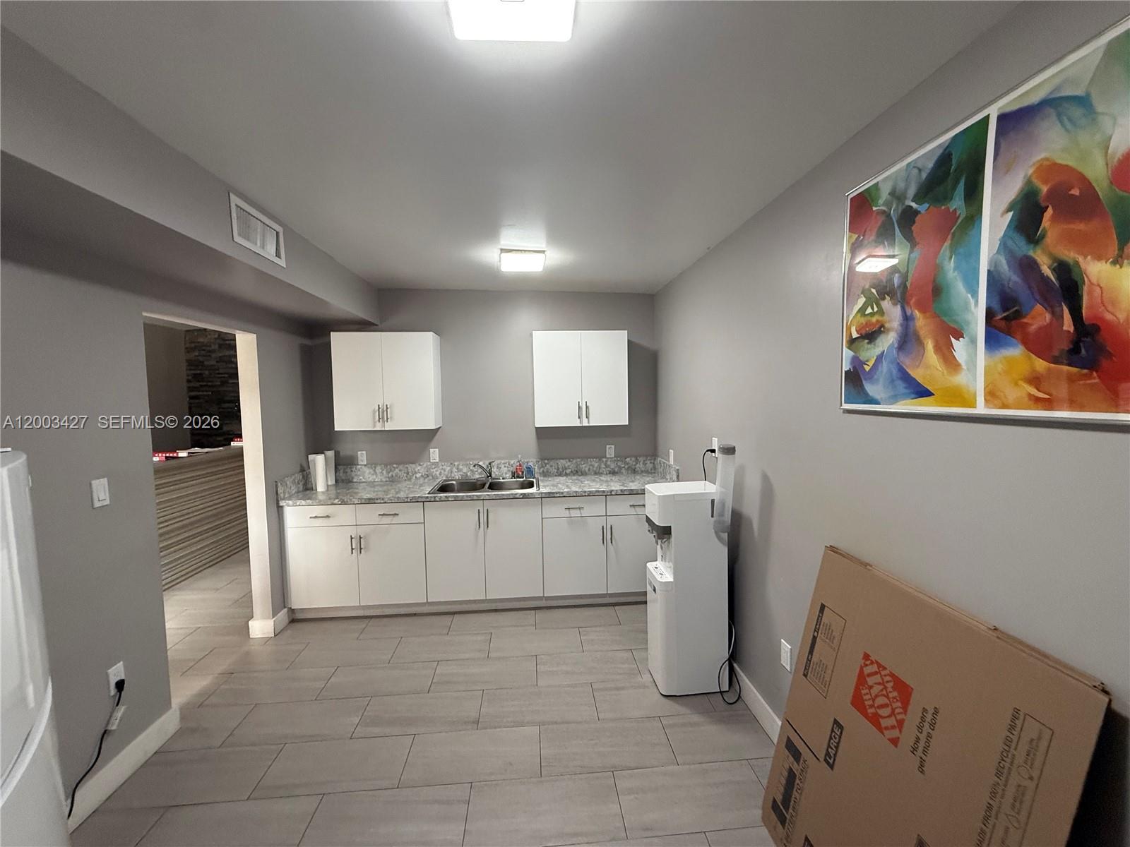 A kitchen area features white cabinets, gray countertops, a sink, and light tile flooring — 16155 SW 117th Ave # B18, Miami FL 33177, MIAMI, FL
