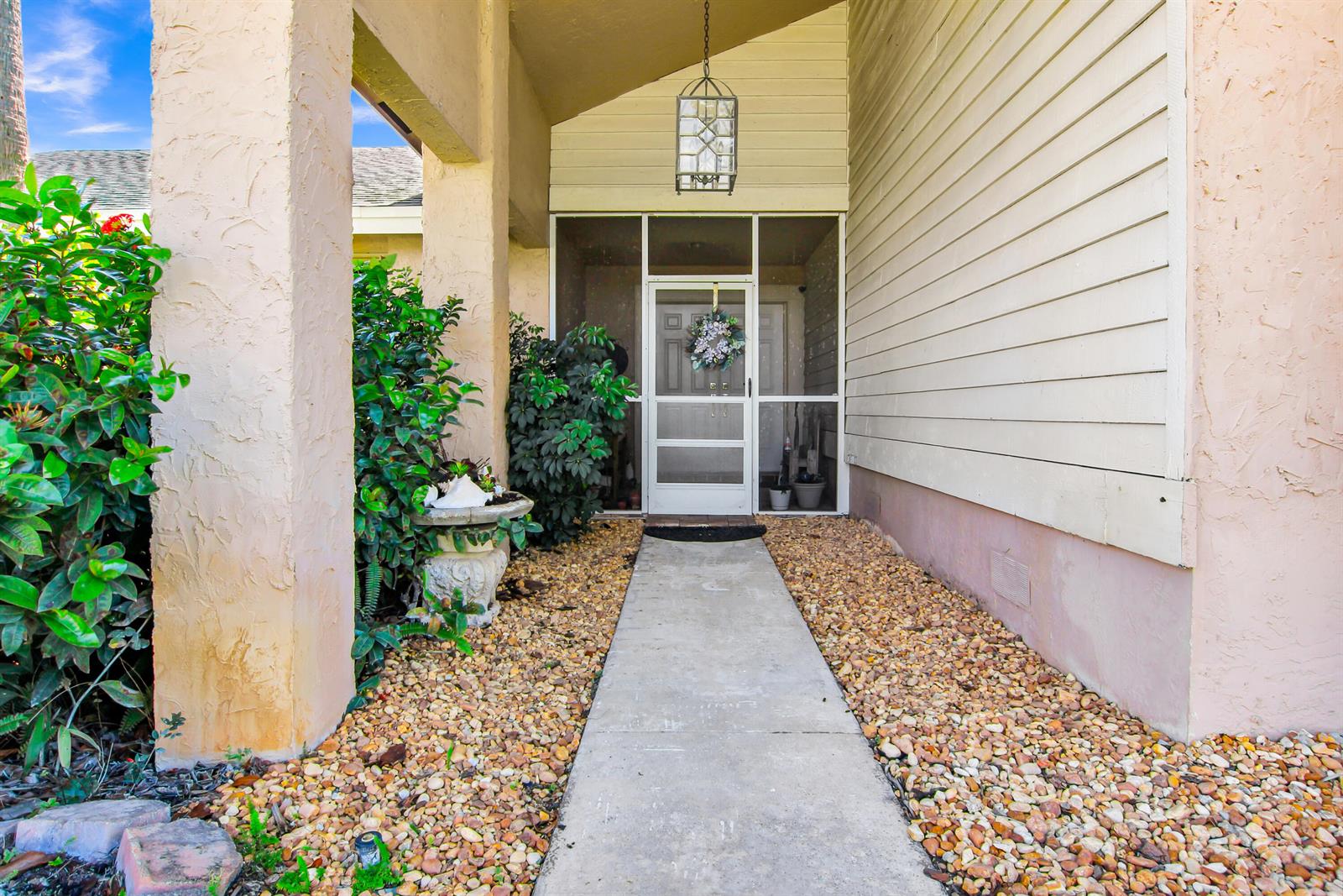 A concrete walkway leads to a screened front door under a covered entryway — 18375 104th Terrace S, Boca Raton FL 33498, BOCA RATON, FL