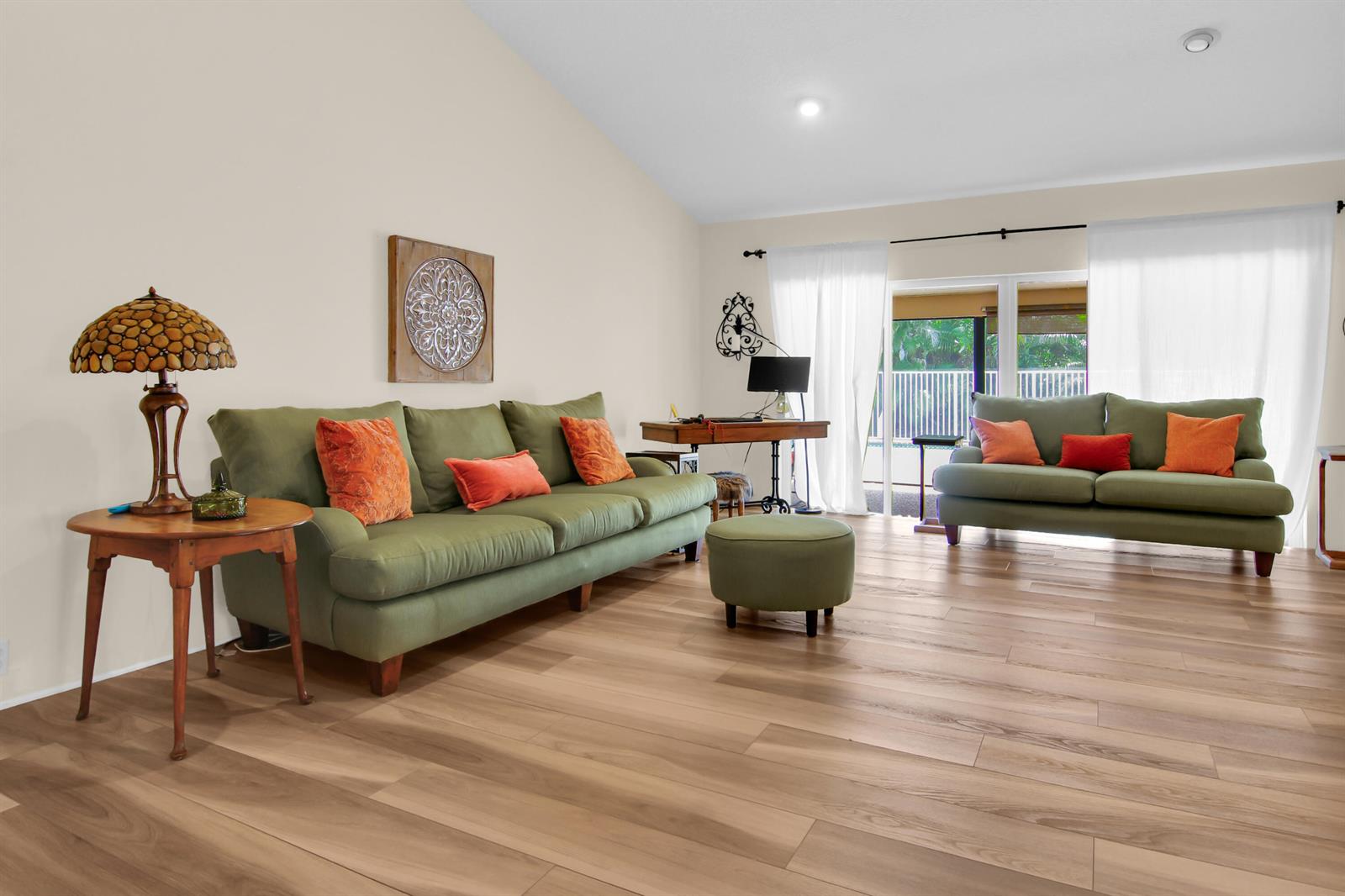 A living room features green sofas, orange accent pillows, a wooden side table, and wood flooring — 18375 104th Terrace S, Boca Raton FL 33498, BOCA RATON, FL