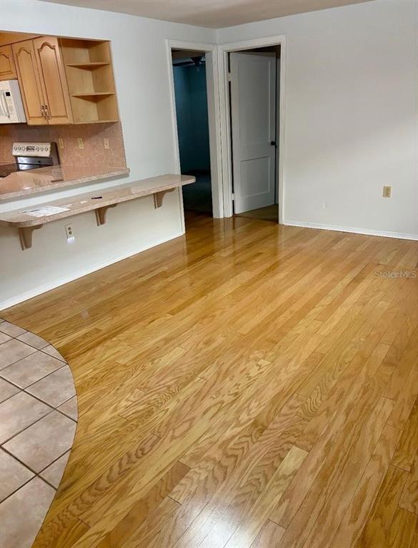 A room with hardwood flooring features a kitchen counter and two doorways — 1690 S MCADOO AVENUE, BARTOW, FL