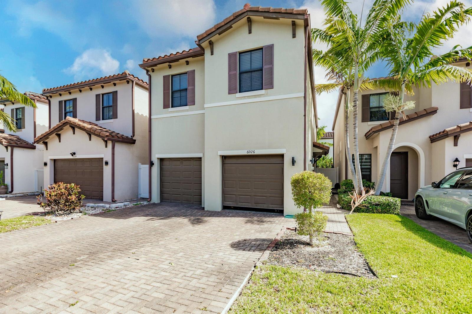 A two-story townhouse with a brown garage door and a paved driveway — 6026 Pine Tree Way # 6026, Riviera Beach FL 33410, RIVIERA BEACH, FL