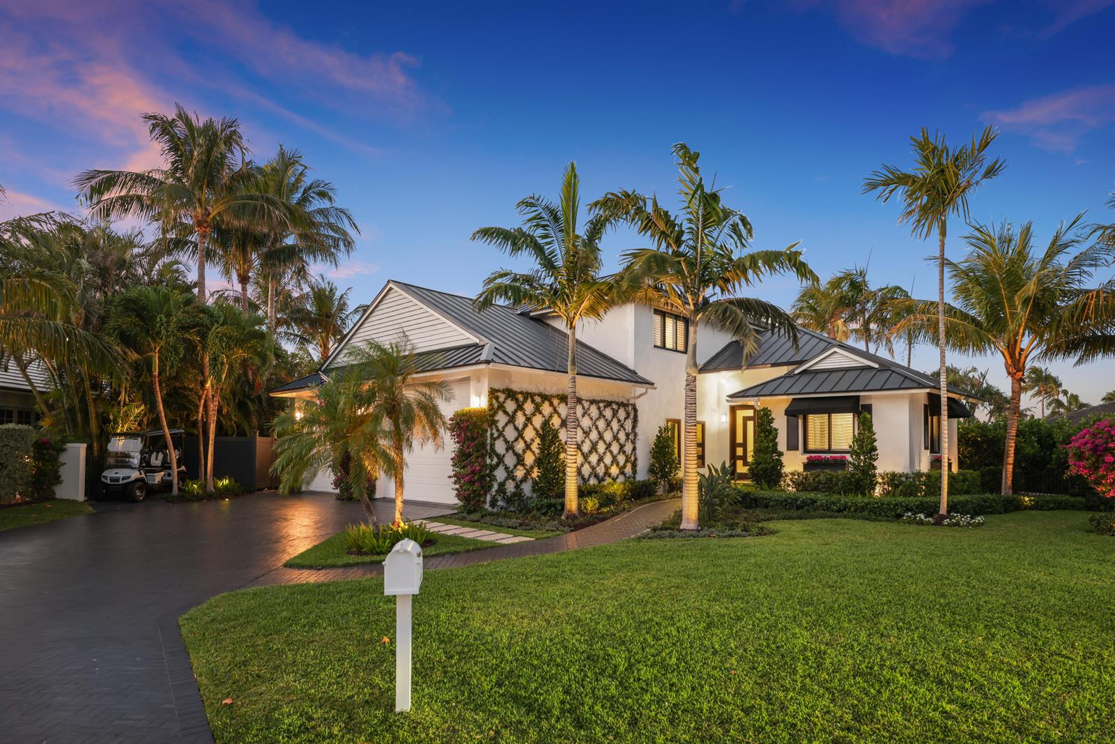A white house with a dark metal roof and palm trees sits on a lawn — 125 Marlin Drive, Ocean Ridge FL 33435, OCEAN RIDGE, FL