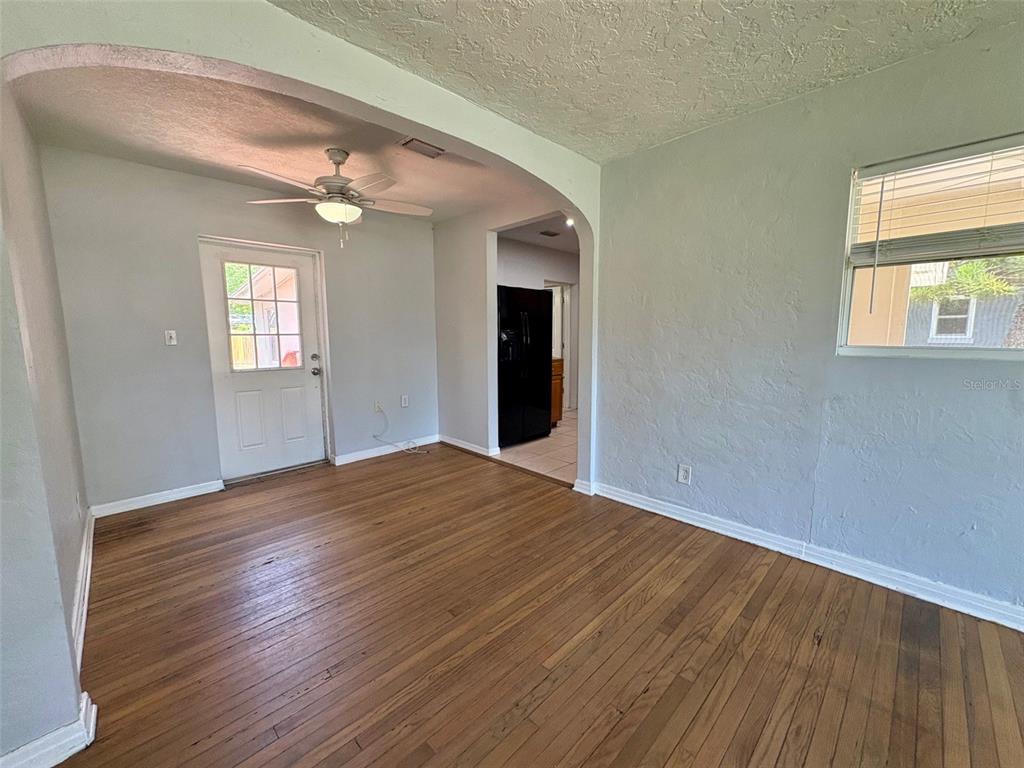 An interior room features hardwood floors, light gray walls, and an arched entryway — 3455 7TH AVENUE N, ST PETERSBURG, FL
