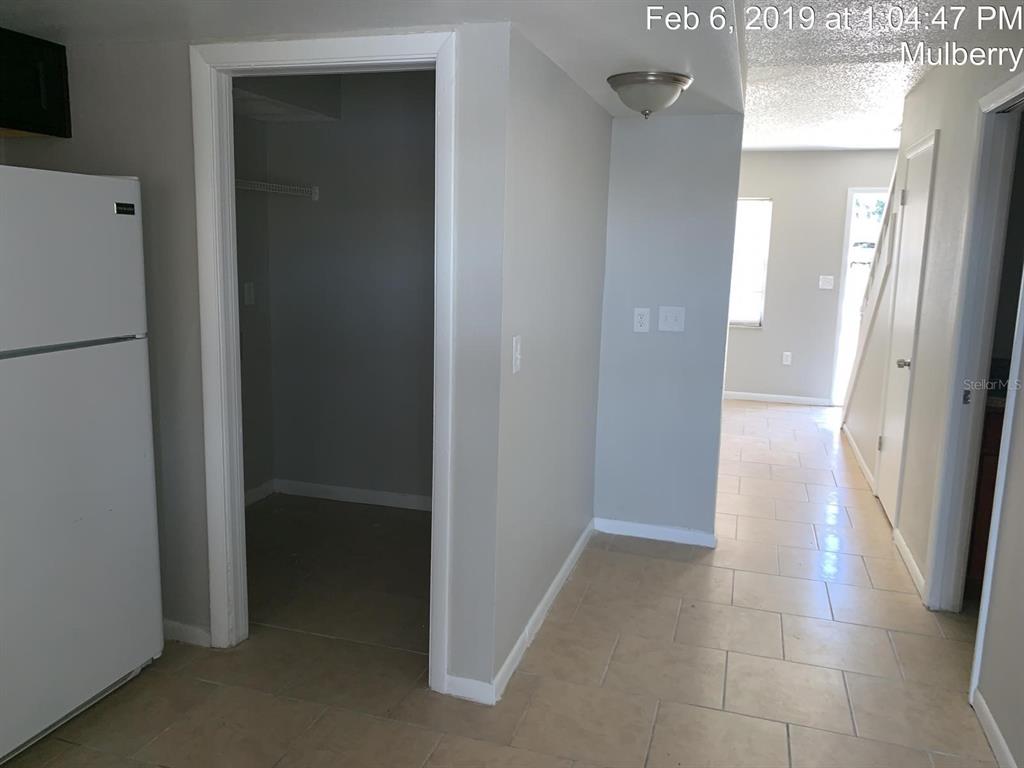 A kitchen area with a white refrigerator, a pantry closet, and a tiled hallway — 181 DIESEL ROAD, MULBERRY, FL