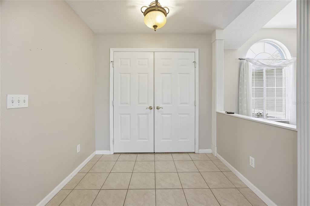 A tiled entryway features white double doors, a light fixture, and a partial wall — 5450 NW 25TH LOOP, OCALA, FL