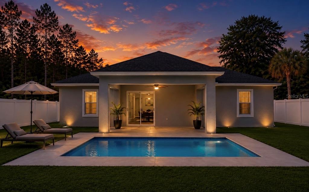 A backyard swimming pool sits in front of a house with a covered patio — 18 FLAMINGO DRIVE, PALM COAST, FL