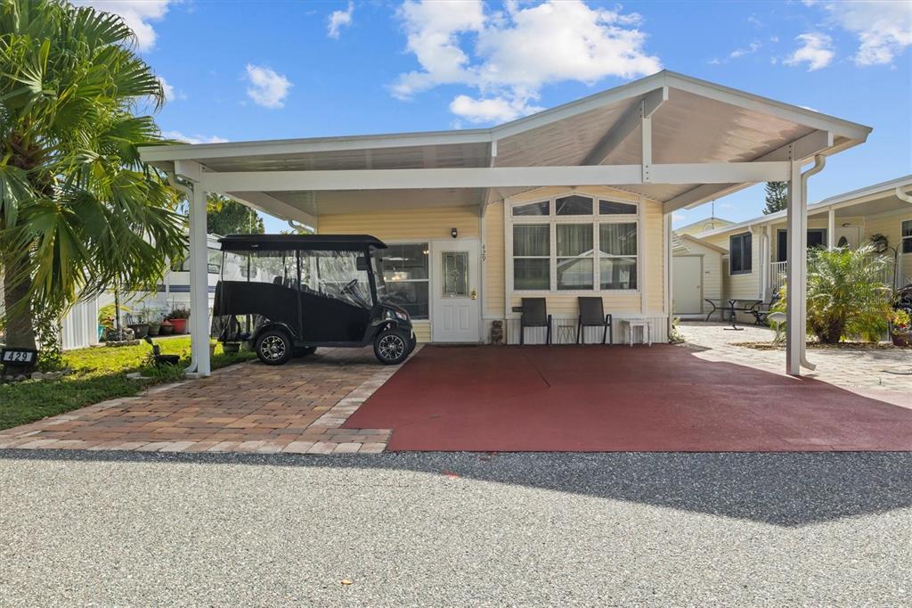 A manufactured home with a carport, a golf cart, and a paved driveway — 429 CITRUS RIDGE DRIVE, DAVENPORT, FL