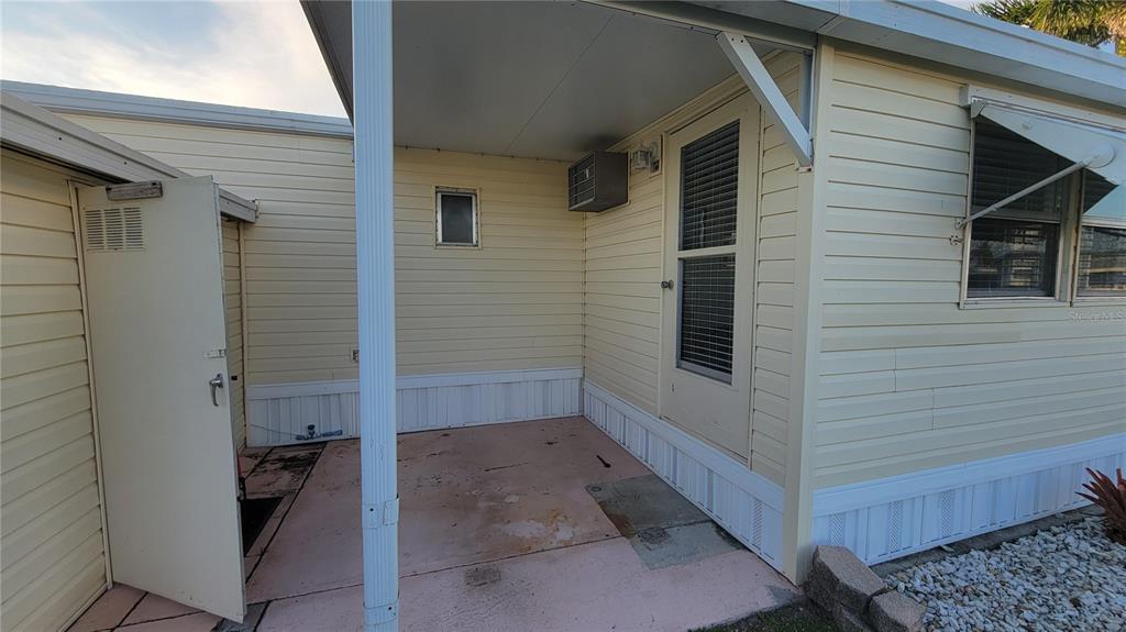A covered patio area features a light-colored exterior wall, a door, and a storage shed — 60 5TH STREET, PUNTA GORDA, FL