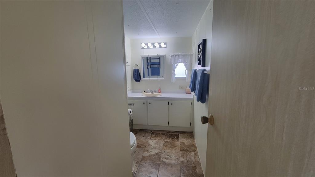 A bathroom features a vanity with a sink, a mirror, and tiled flooring — 60 5TH STREET, PUNTA GORDA, FL