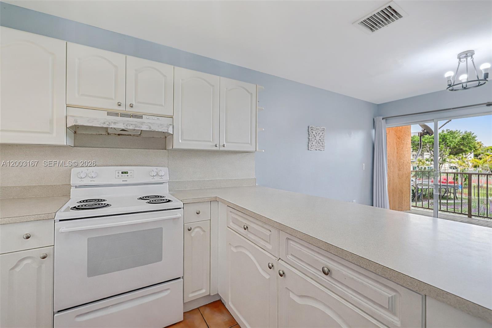 A kitchen features white cabinets, a white electric stove, and a light-colored countertop — 6255 Kendale Lakes Cir # 218, Miami FL 33183, MIAMI, FL