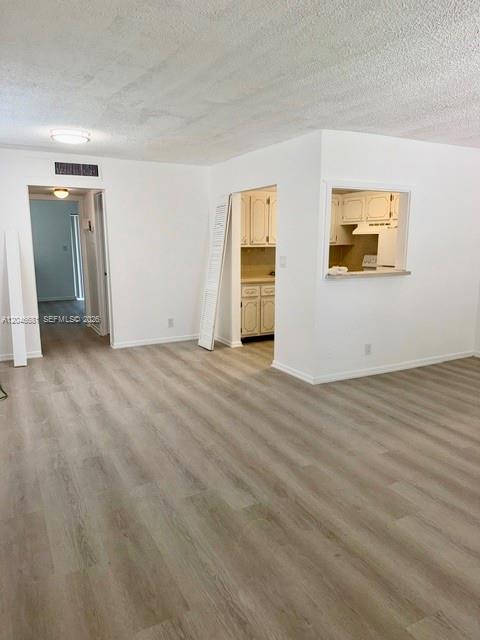 An interior view shows a living area with light wood flooring and a kitchen pass-through — 41 Salisbury # B, West Palm Beach FL 33417, WEST PALM BEACH, FL