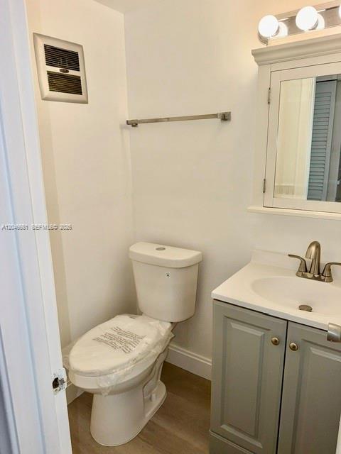 A bathroom featuring a white toilet, a gray vanity with a sink, and a wall vent — 41 Salisbury # B, West Palm Beach FL 33417, WEST PALM BEACH, FL