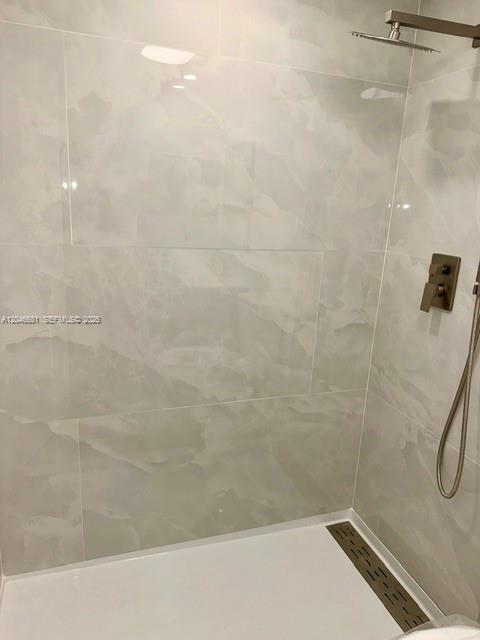 A walk-in shower features light-colored marble-look wall tiles, a rainfall showerhead, and a linear drain — 41 Salisbury # B, West Palm Beach FL 33417, WEST PALM BEACH, FL