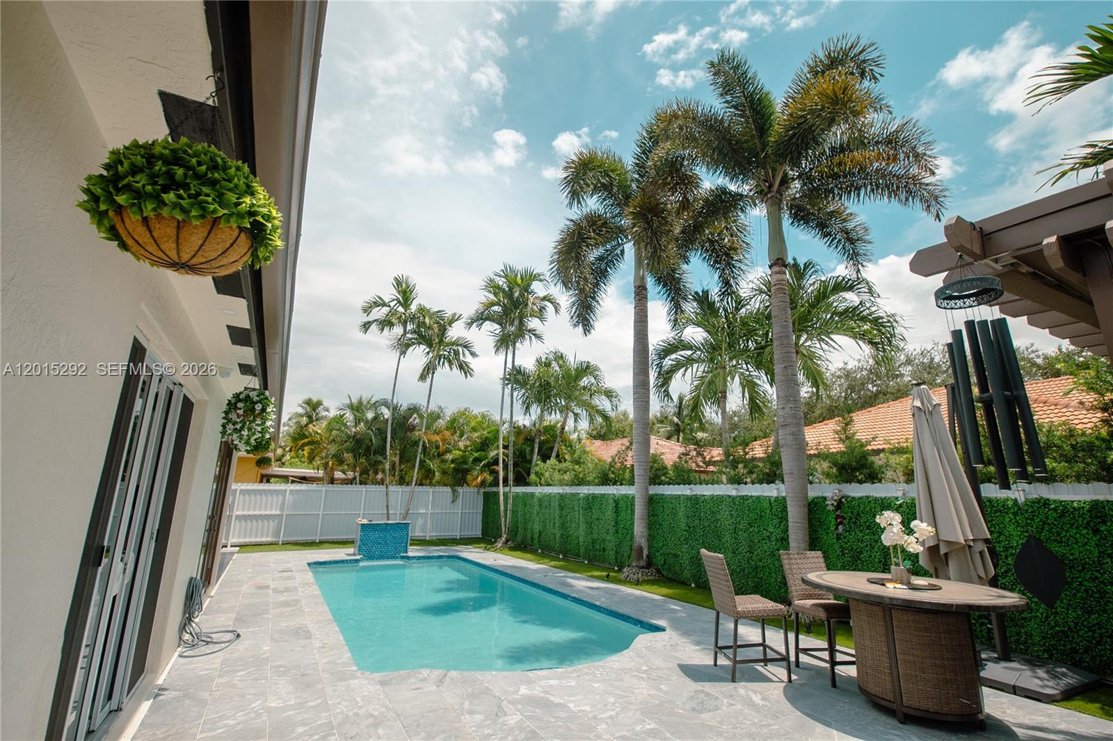 A single-story house with a white exterior, black roof, and a modern concrete driveway — 7814 NW 165th St, Miami Lakes FL 33016, MIAMI LAKES, FL