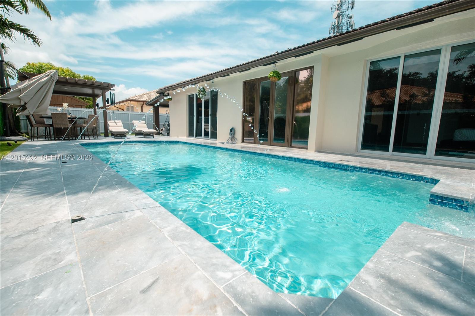 A single-story white house with a dark tile roof and a modern paved driveway — 7814 NW 165th St, Miami Lakes FL 33016, MIAMI LAKES, FL
