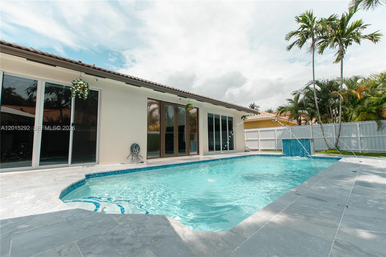 A white house with a tiled roof features a covered patio and a swimming pool — 7814 NW 165th St, Miami Lakes FL 33016, MIAMI LAKES, FL