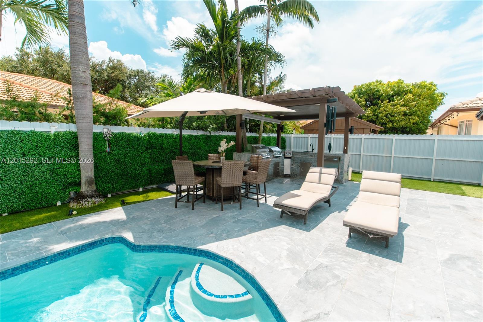 A covered patio with black columns and a tiled floor sits beside a white house — 7814 NW 165th St, Miami Lakes FL 33016, MIAMI LAKES, FL