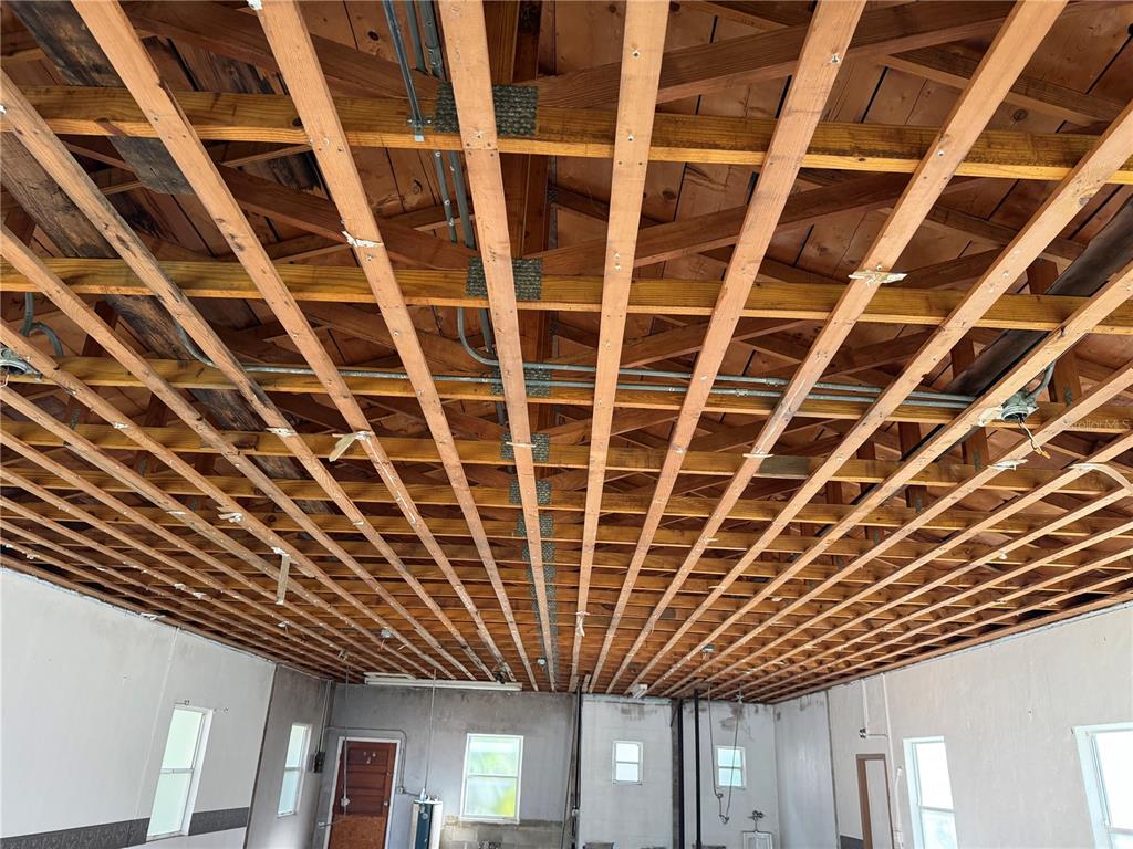 An unfinished room features exposed wooden ceiling trusses and a grid of furring strips — 844 KLONDIKE STREET, WINTER GARDEN, FL