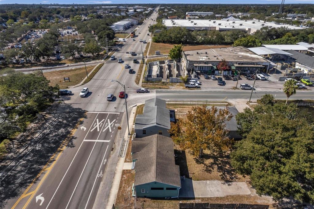 An aerial view shows a green house next to a road with a railroad crossing — 2169 & 2179 22ND AVENUE N, ST PETERSBURG, FL