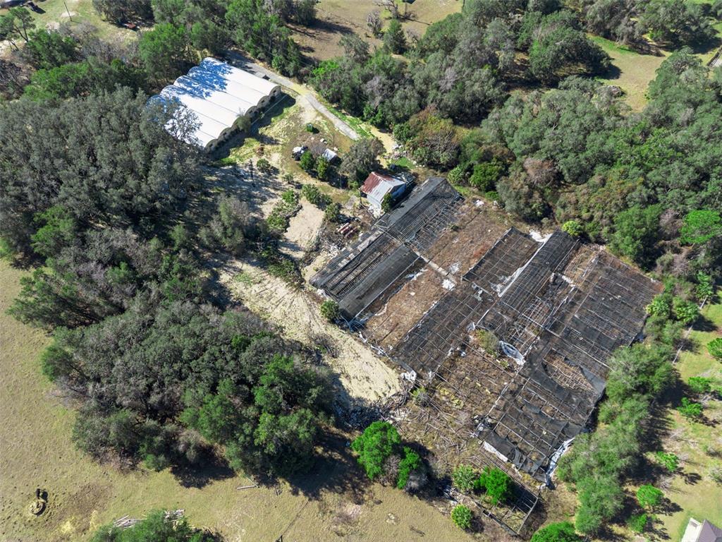 An aerial view shows a rural property with a white building and large greenhouse structures — 1909 HAAS ROAD, APOPKA, FL