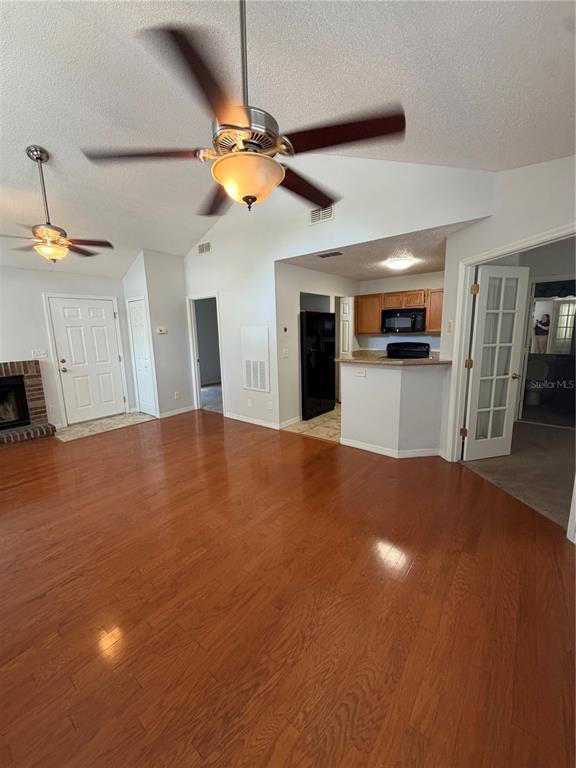 A living room with hardwood floors, a ceiling fan, and an open kitchen area — 949 BIRD BAY COURT UNIT 201, LAKE MARY, FL