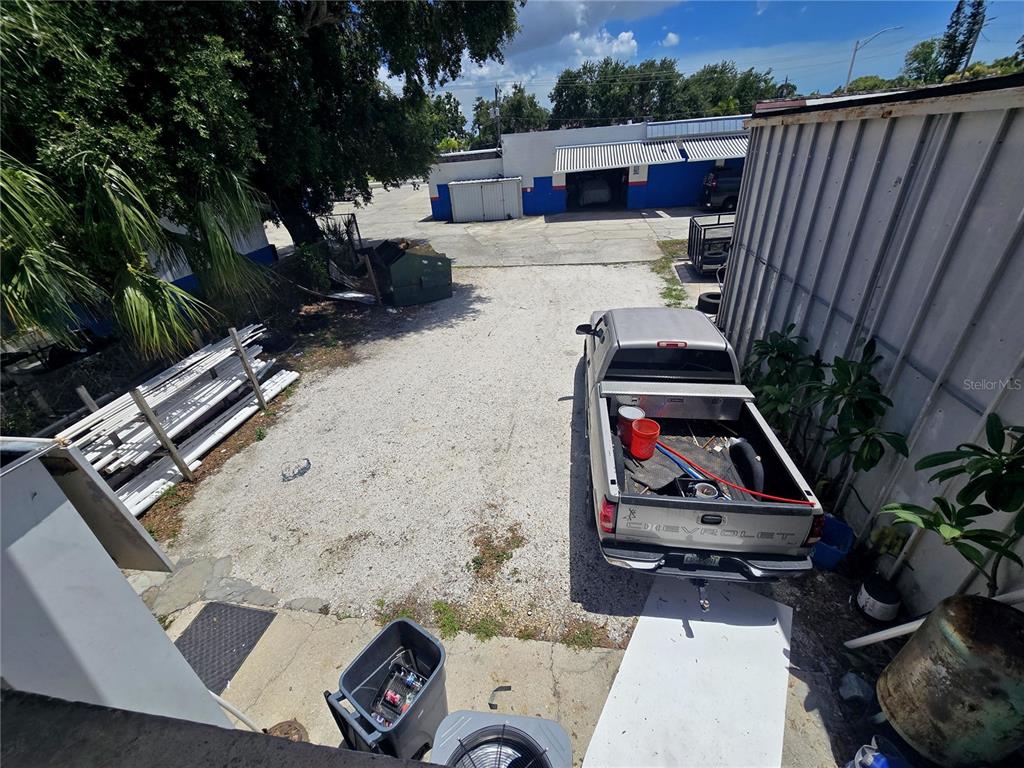An elevated view shows a gravel parking area with a pickup truck and building exteriors — 1315 12TH AVENUE W, BRADENTON, FL