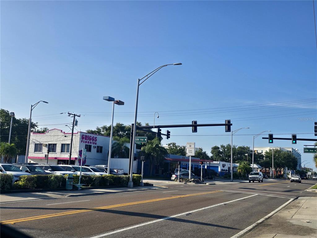 An exterior view of a street intersection featuring a plumbing business and a tire shop — 1315 12TH AVENUE W, BRADENTON, FL
