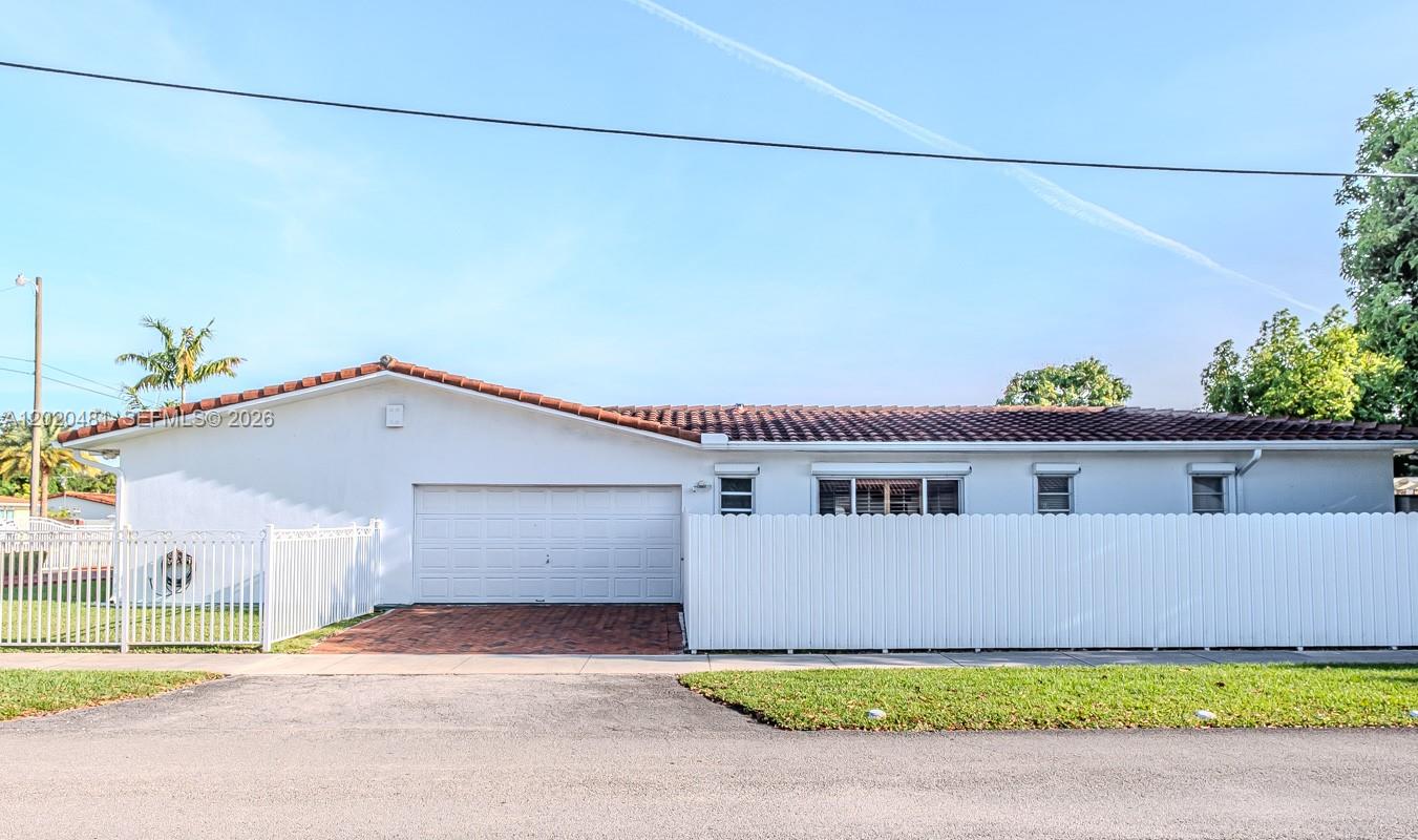 A white single-story house features a two-car garage, a tiled roof, and a white fence — 3400 SW 108th Ave, Miami FL 33165, MIAMI, FL