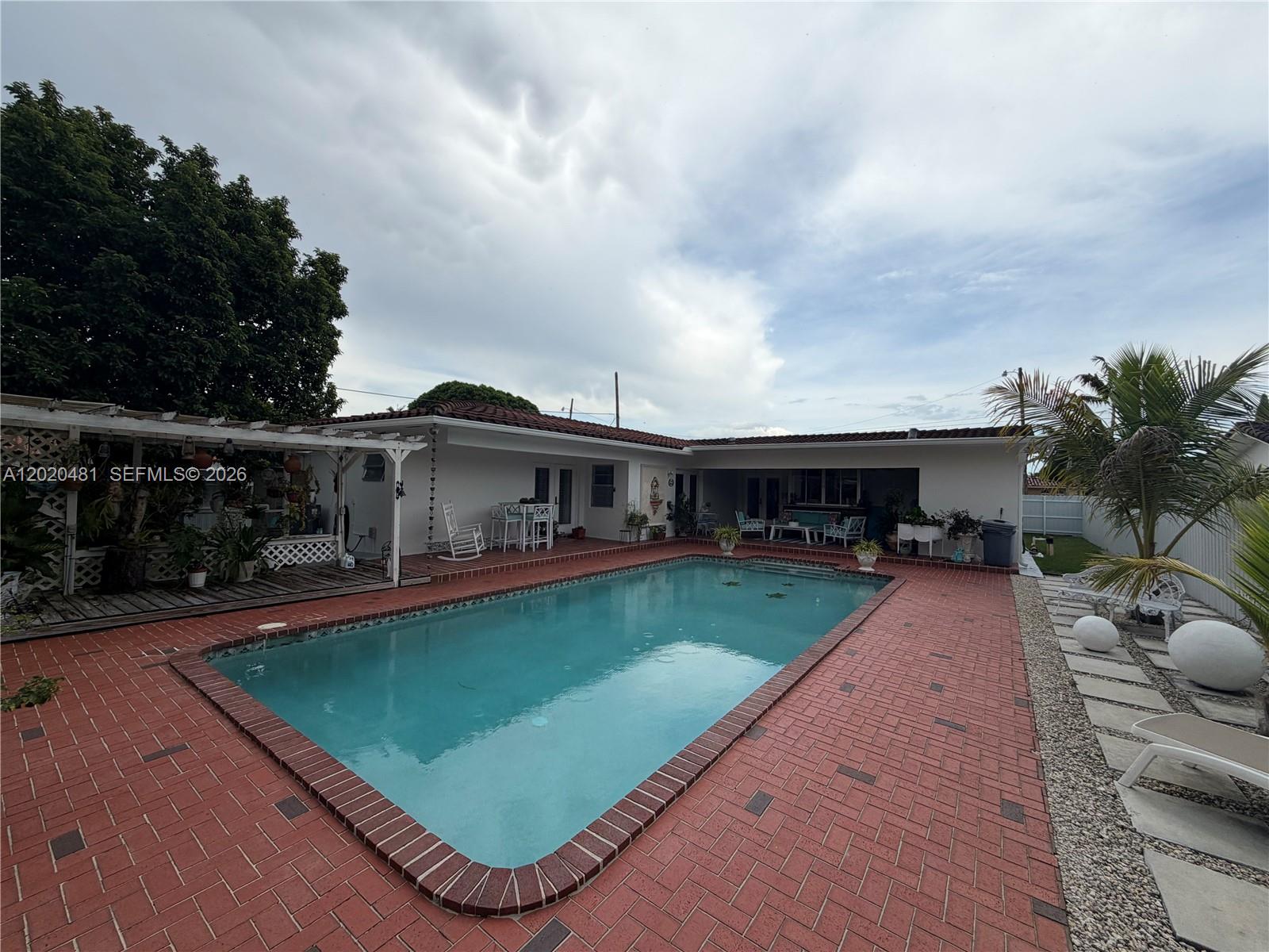 A rectangular swimming pool sits in a backyard patio paved with red bricks — 3400 SW 108th Ave, Miami FL 33165, MIAMI, FL