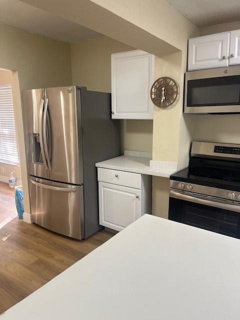A kitchen features stainless steel appliances, white cabinets, and light-colored countertops — 734 SW 8th Street, Dania Beach FL 33004, DANIA BEACH, FL