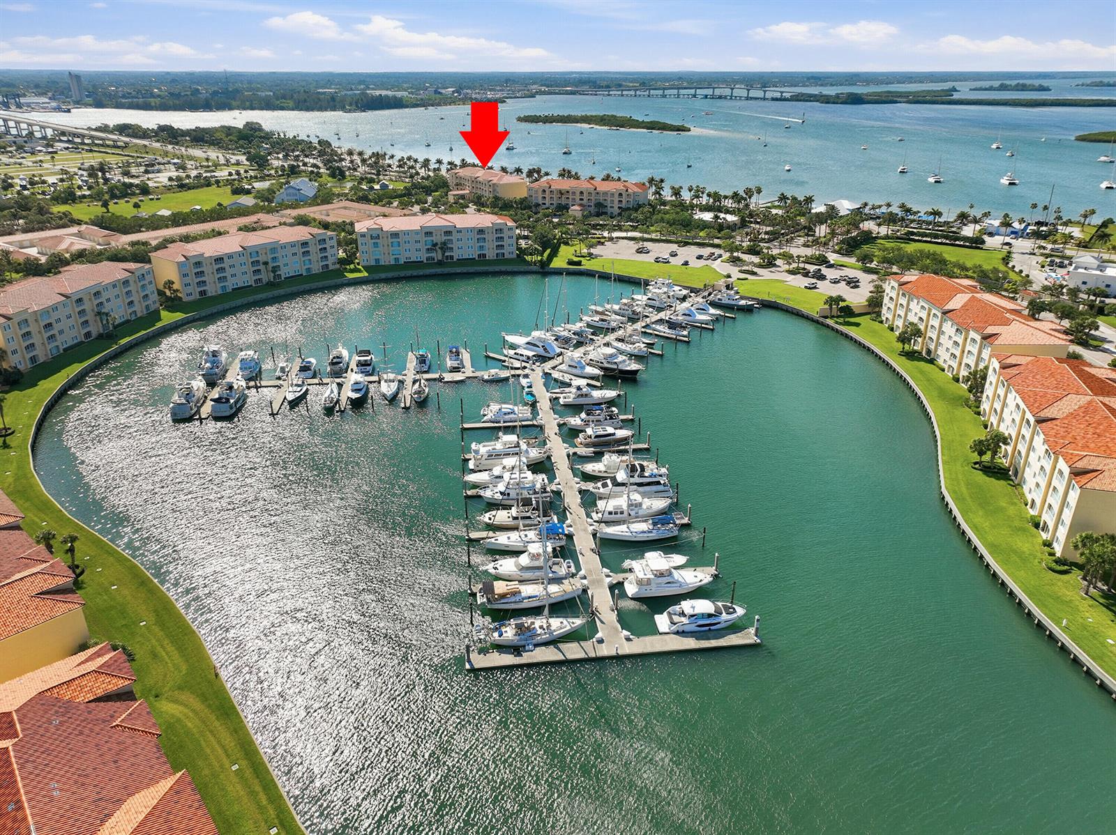 An aerial view shows a marina with numerous docked boats surrounded by multi-story residential buildings — FORT PIERCE, FL