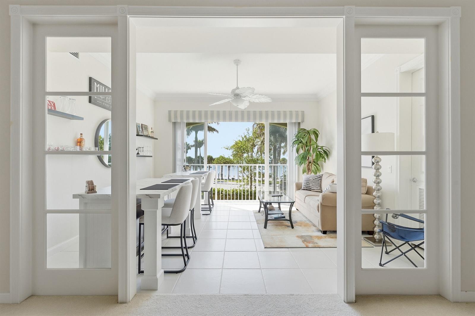 A bright living area with a bar, sofa, and sliding doors opening to a balcony view — FORT PIERCE, FL