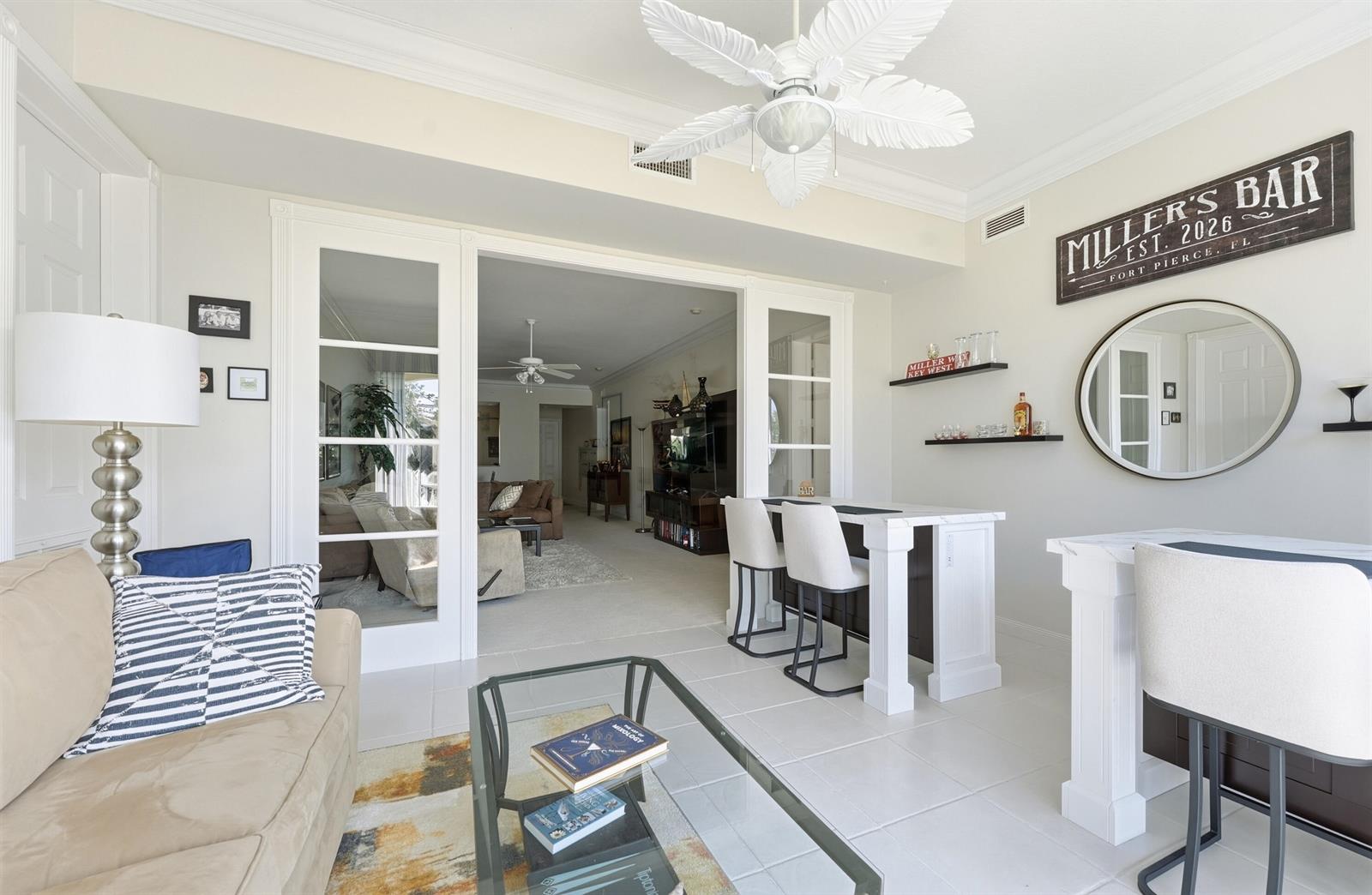 A living room features a bar area with stools, a glass coffee table, and French doors — FORT PIERCE, FL