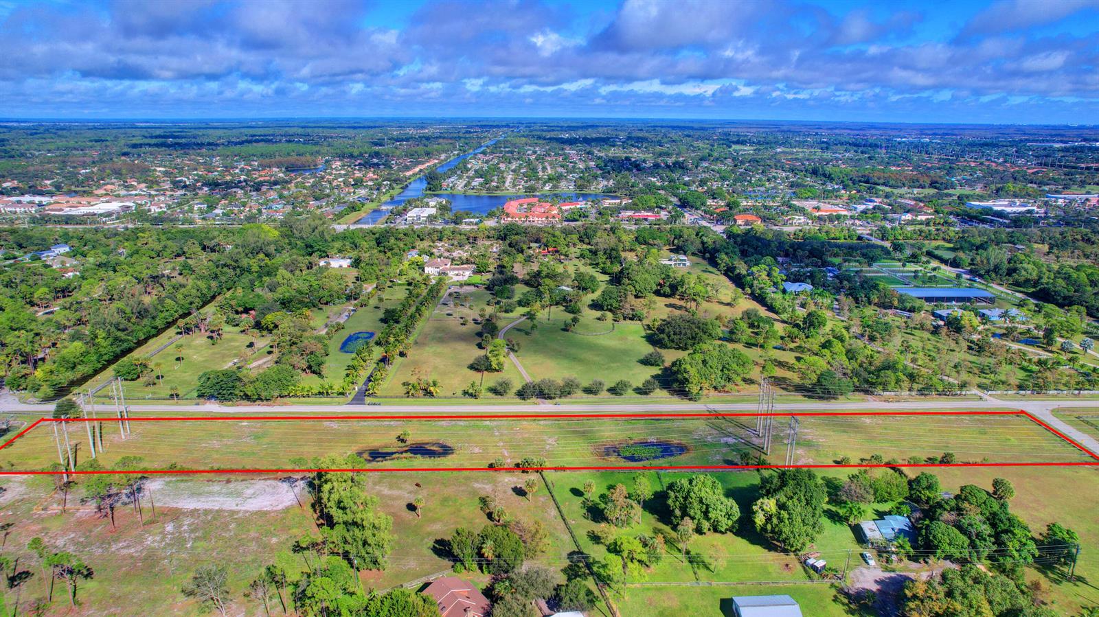 An aerial view shows a large rectangular plot of land featuring power lines and ponds — 0000 Acme Road, Wellington FL 33414, WELLINGTON, FL