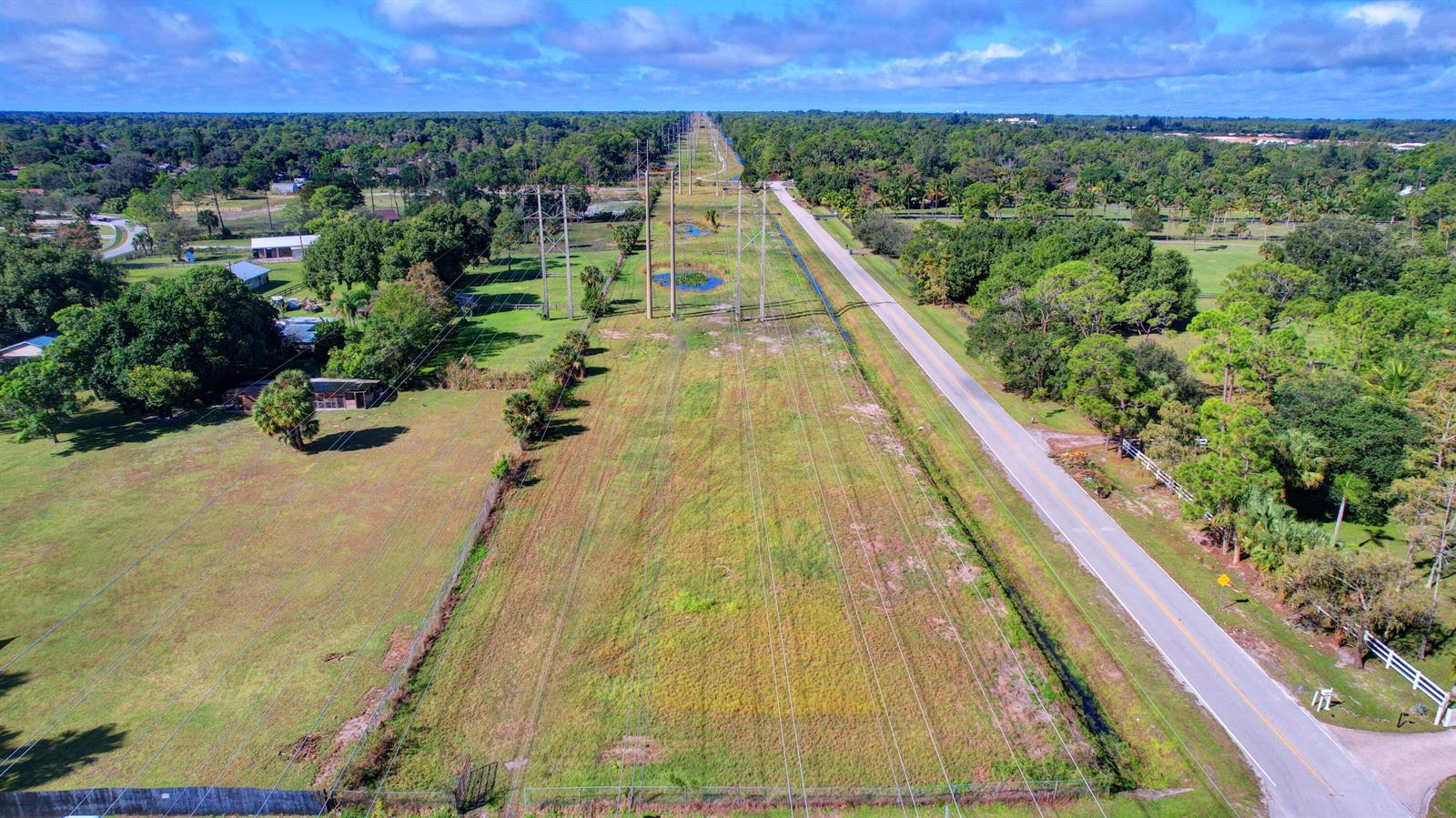 An aerial view shows a grassy utility easement with power lines running parallel to a road — 0000 Acme Road, Wellington FL 33414, WELLINGTON, FL