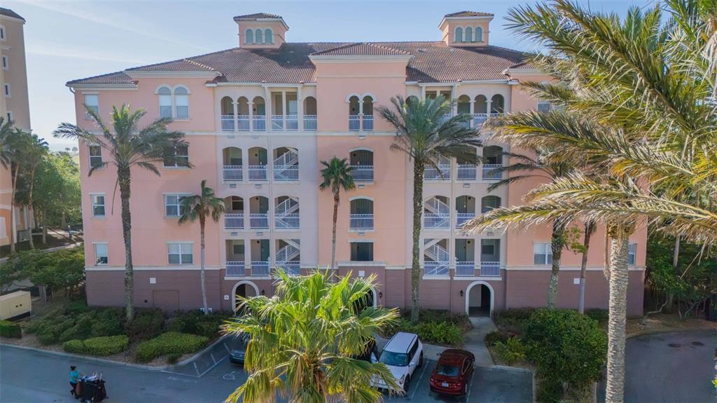 A multi-story pink apartment building with balconies and palm trees in front — 5 OCEAN CREST WAY UNIT 1411, PALM COAST, FL