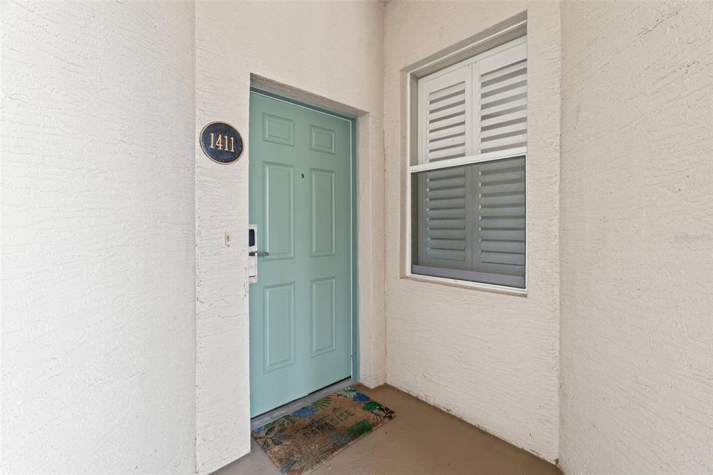 A light blue front door with the number 1411 is set in a stucco exterior wall — 5 OCEAN CREST WAY UNIT 1411, PALM COAST, FL