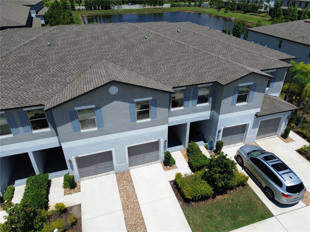 An aerial view of a multi-unit townhouse complex with gray siding and attached garages — 11826 DUMAINE VALLEY ROAD, RIVERVIEW, FL