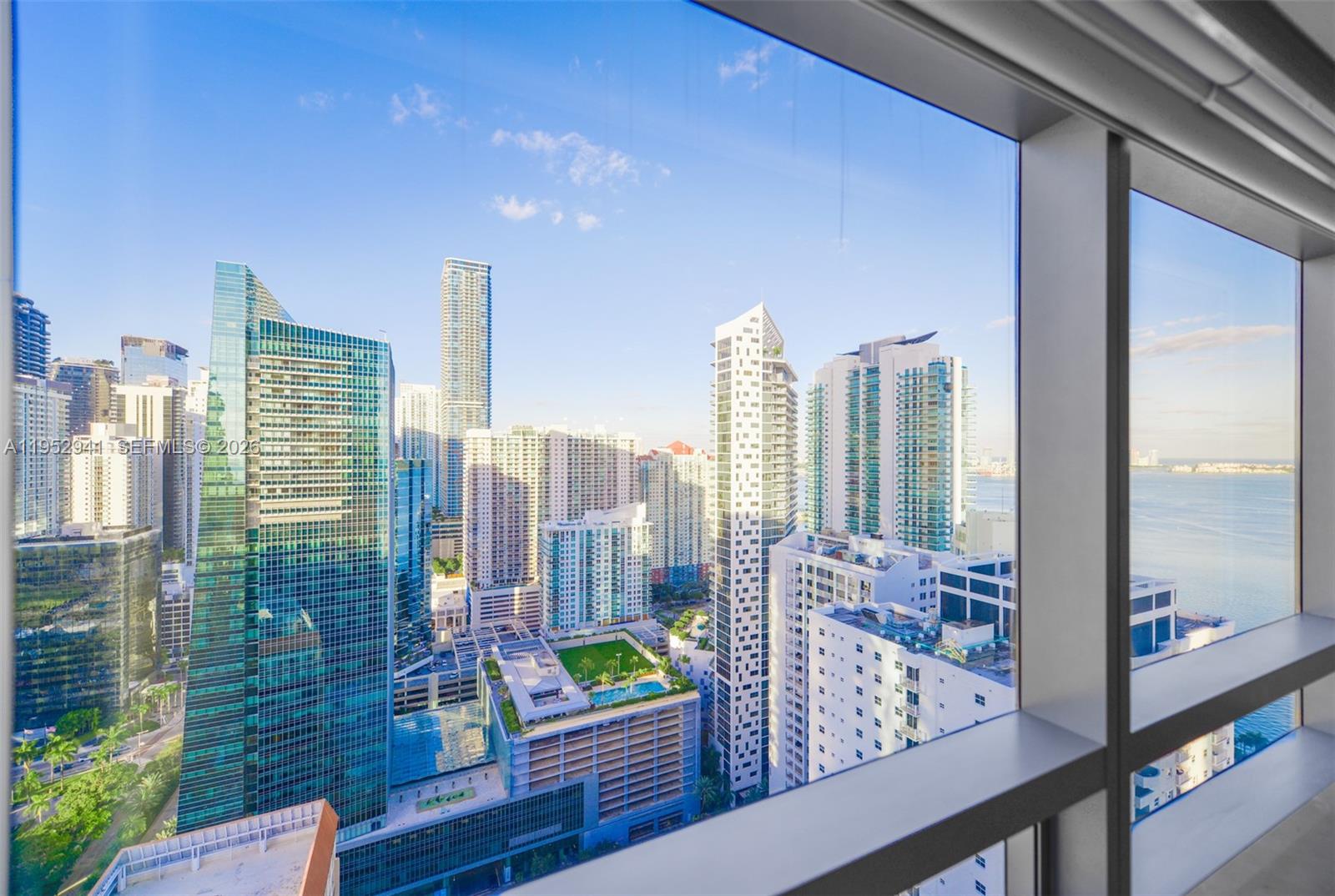 A high-rise view of the Miami skyline featuring numerous glass skyscrapers and the ocean — 1435 Brickell Ave # 3510, Miami FL 33131, MIAMI, FL