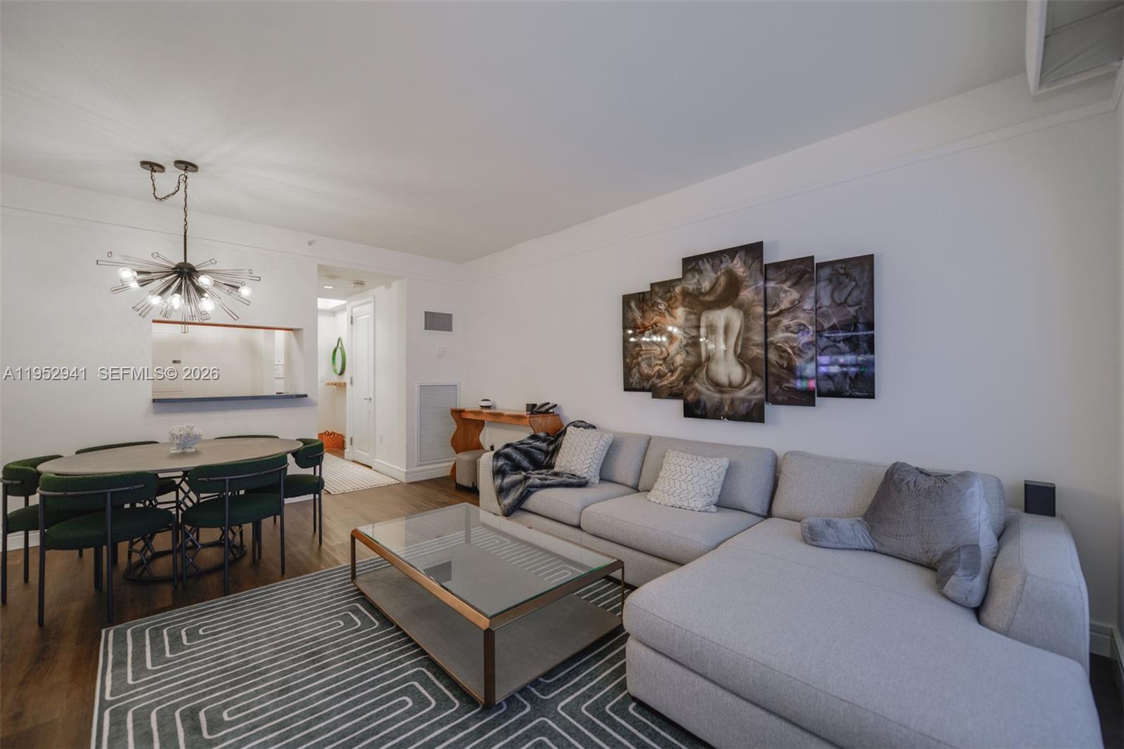 A living room features a grey sectional sofa, a glass coffee table, and dining area — 1435 Brickell Ave # 3510, Miami FL 33131, MIAMI, FL